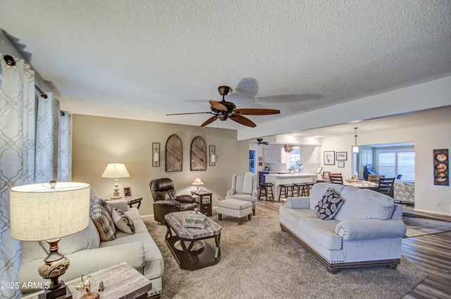 living room featuring a textured ceiling and ceiling fan