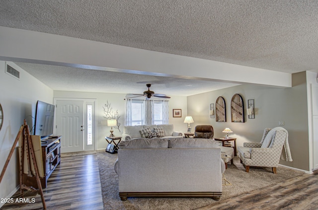 living room featuring ceiling fan, a textured ceiling, and hardwood / wood-style flooring