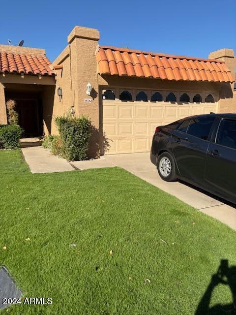 view of property exterior with a garage and a yard