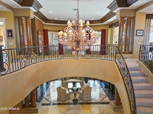 entryway featuring ornate columns, recessed lighting, ornamental molding, and an inviting chandelier