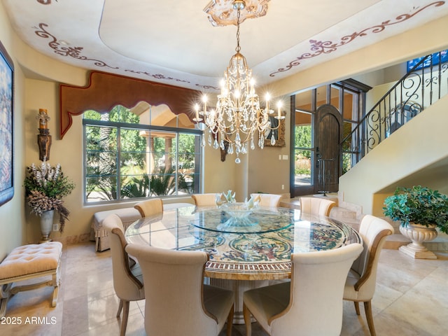 dining area featuring a wealth of natural light, baseboards, an inviting chandelier, and stairs