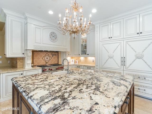 kitchen with glass insert cabinets, white cabinetry, and a center island with sink