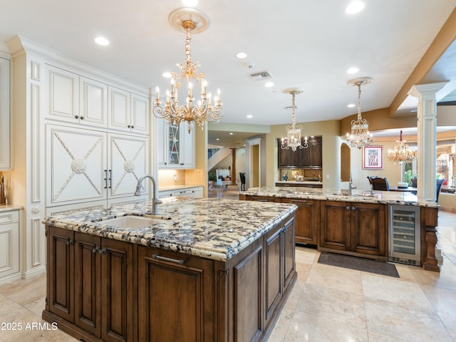 kitchen with beverage cooler, a spacious island, a sink, and dark brown cabinetry