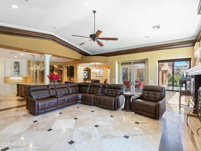 living area featuring arched walkways, lofted ceiling, visible vents, ornamental molding, and ceiling fan with notable chandelier