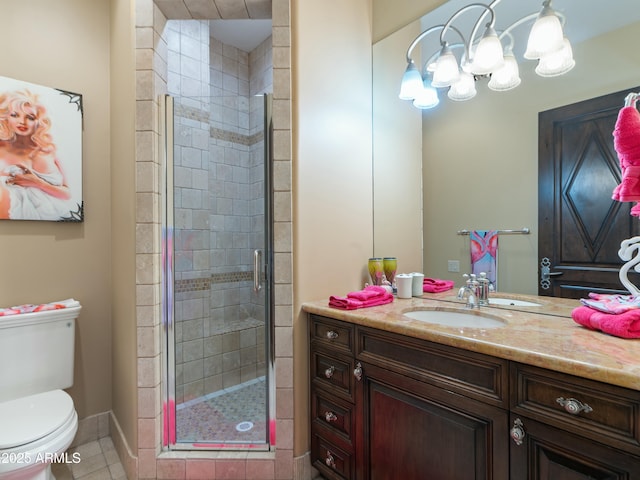 bathroom featuring tile patterned flooring, toilet, vanity, baseboards, and a stall shower