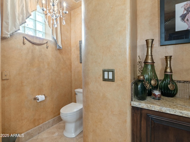 bathroom featuring baseboards, toilet, an inviting chandelier, tile patterned flooring, and vanity