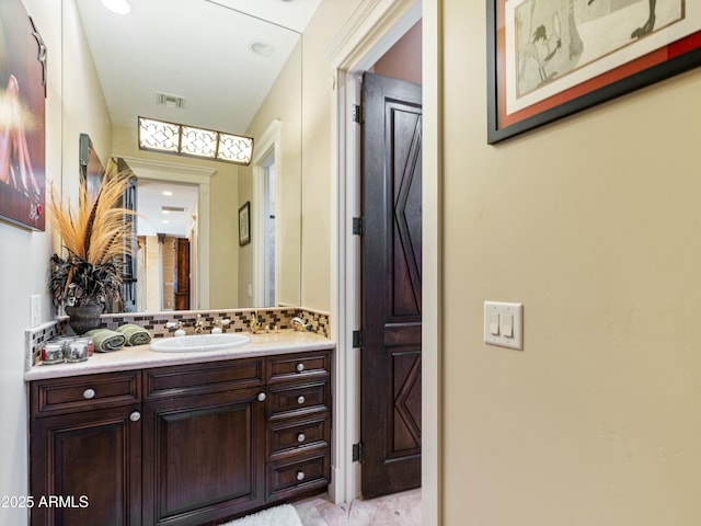 bathroom with visible vents, decorative backsplash, and vanity