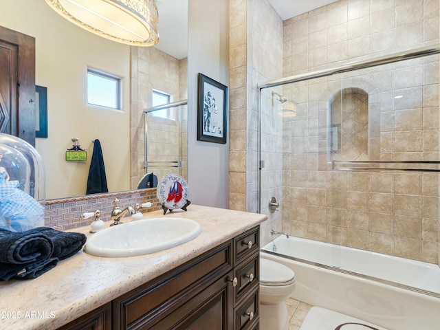 full bath with shower / bath combination with glass door, vanity, toilet, and tile patterned floors