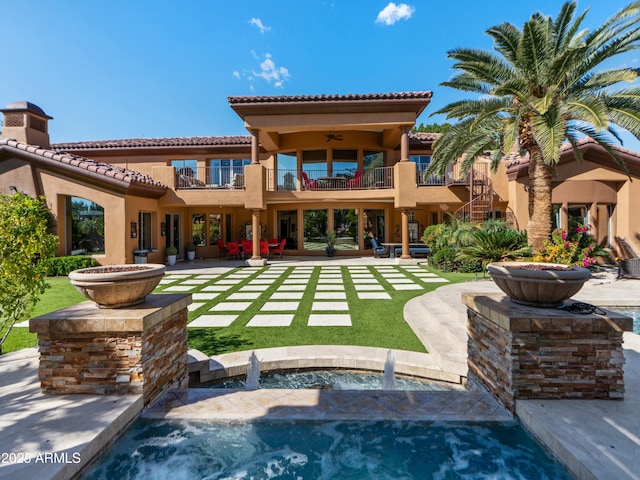 back of house featuring a balcony, ceiling fan, a tile roof, a patio area, and stucco siding