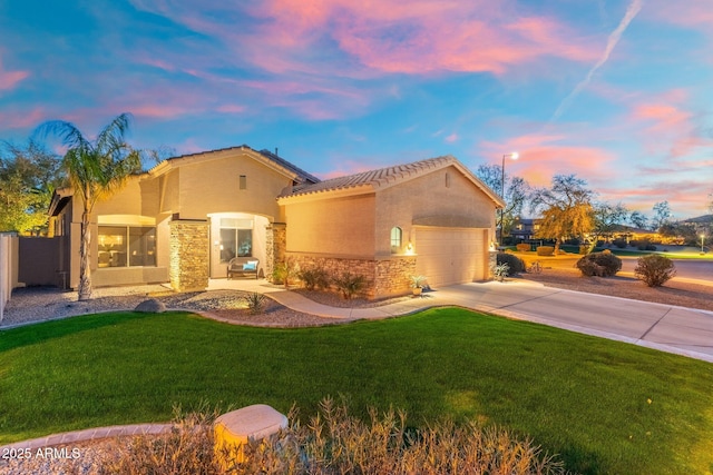 mediterranean / spanish home with stone siding, a front lawn, driveway, and stucco siding