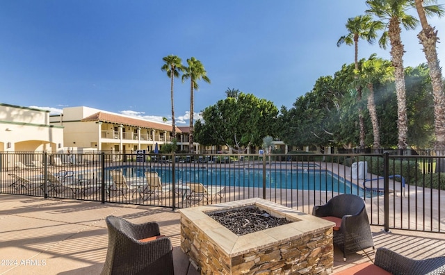 view of swimming pool featuring a patio and an outdoor fire pit