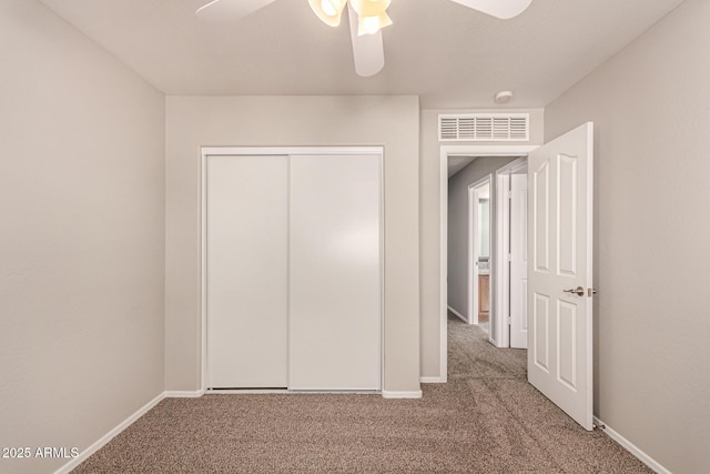 unfurnished bedroom featuring a closet, ceiling fan, and carpet