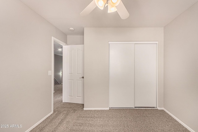 unfurnished bedroom with carpet floors, a closet, and ceiling fan