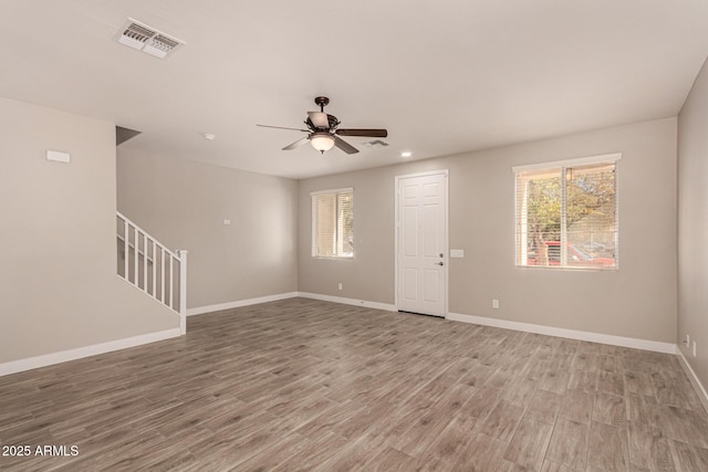 spare room featuring wood-type flooring, plenty of natural light, and ceiling fan