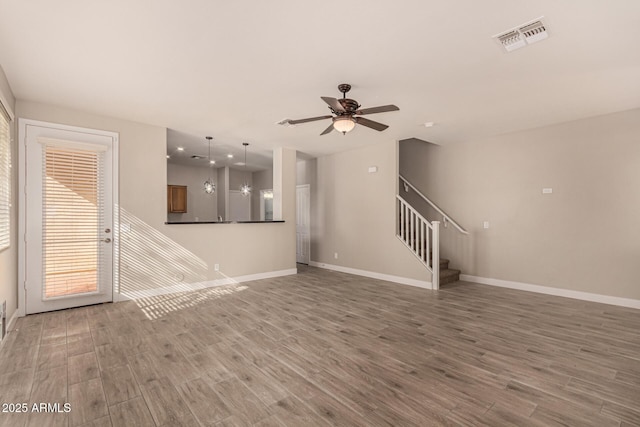 unfurnished living room with hardwood / wood-style flooring and ceiling fan