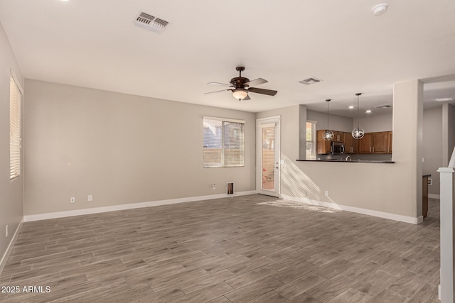 unfurnished living room with hardwood / wood-style floors and ceiling fan