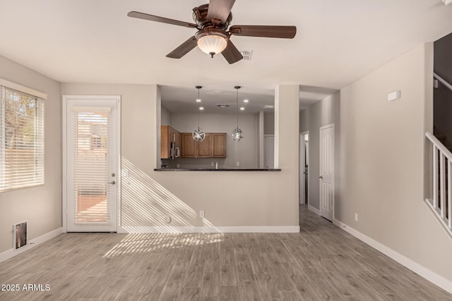 unfurnished living room with ceiling fan and light hardwood / wood-style flooring