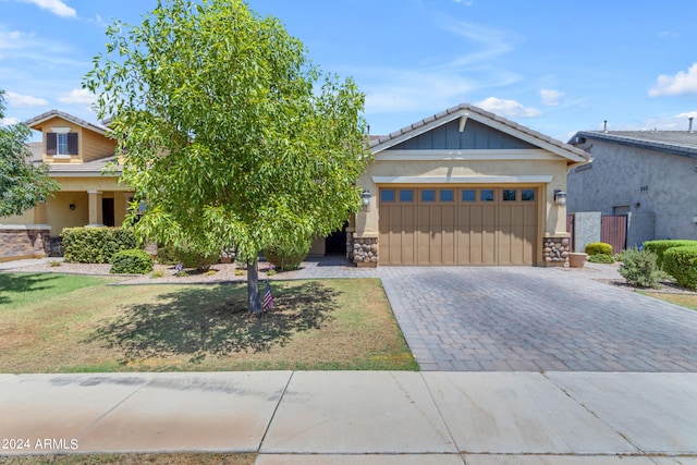 craftsman inspired home with a garage and a front lawn