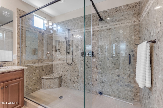 bathroom with a shower with shower door and vanity