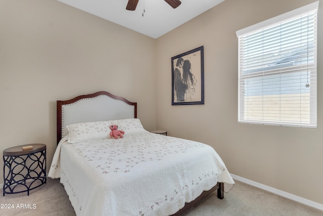 bedroom featuring light carpet, multiple windows, and ceiling fan