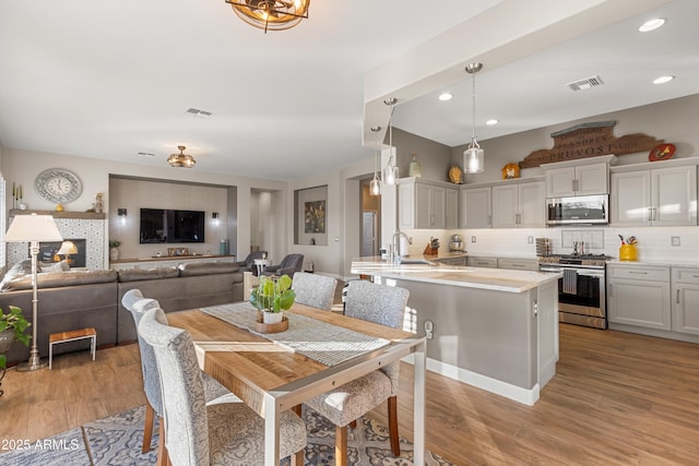 dining area with sink and light hardwood / wood-style floors