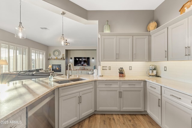 kitchen featuring hanging light fixtures, tasteful backsplash, and sink