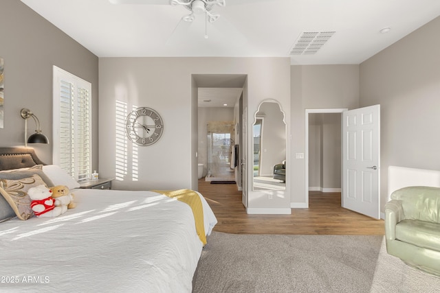 bedroom featuring ensuite bathroom, wood-type flooring, and ceiling fan