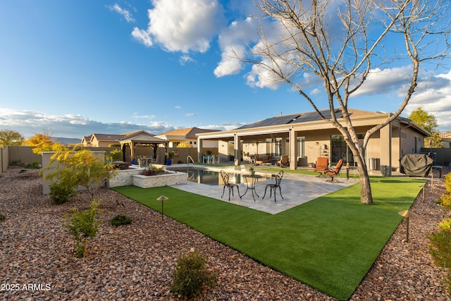 back of property featuring solar panels, a lawn, a fenced in pool, a gazebo, and a patio area