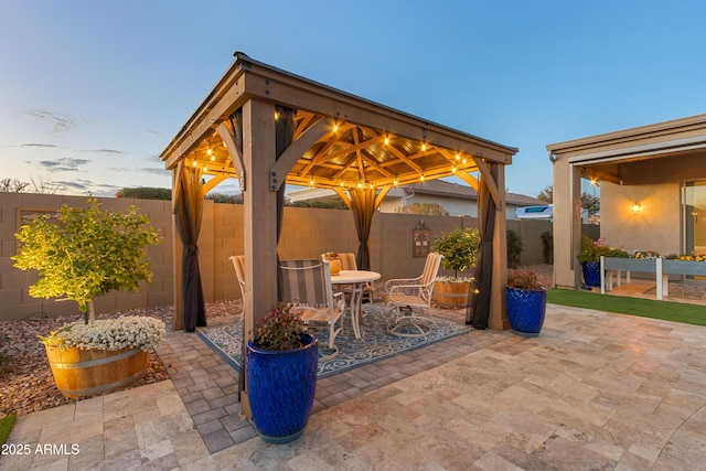 patio terrace at dusk featuring a gazebo