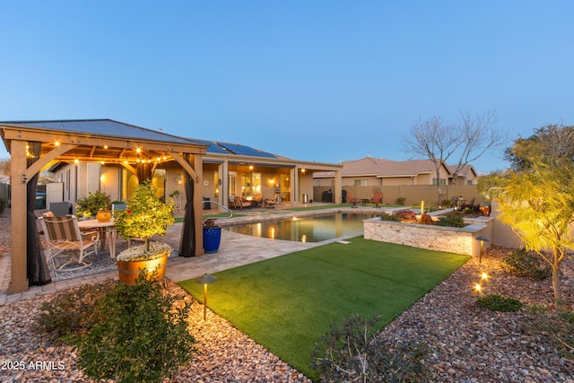 exterior space featuring a lawn, a patio area, and solar panels