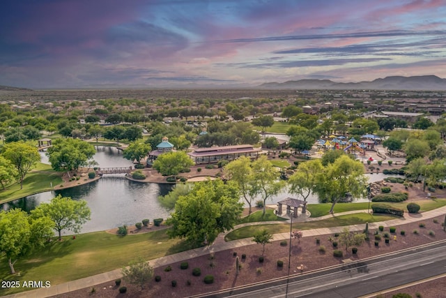 aerial view at dusk featuring a water view