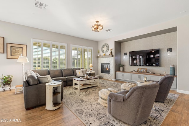 living room with light hardwood / wood-style floors and a tile fireplace