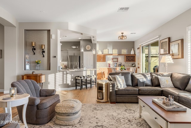 living room with sink and light hardwood / wood-style flooring