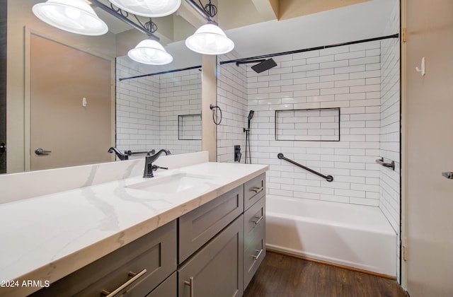 bathroom featuring vanity, hardwood / wood-style floors, and tiled shower / bath combo