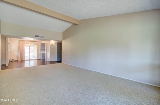 empty room featuring lofted ceiling with beams, carpet flooring, a textured ceiling, and an inviting chandelier