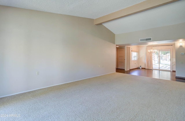 carpeted empty room featuring an inviting chandelier, a textured ceiling, and vaulted ceiling with beams