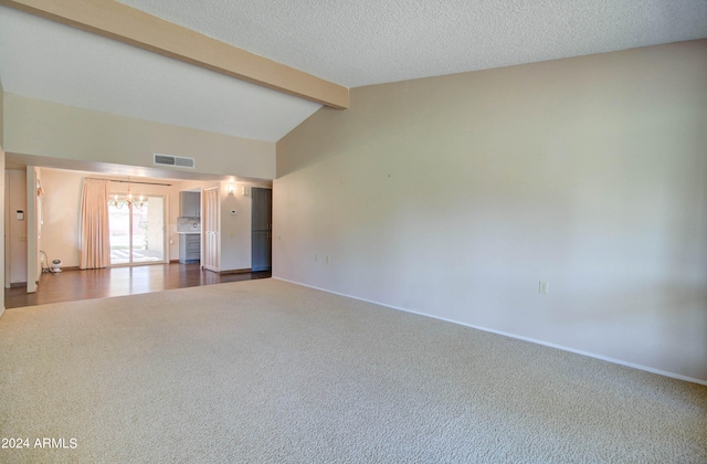 unfurnished living room with dark colored carpet, a textured ceiling, and vaulted ceiling with beams