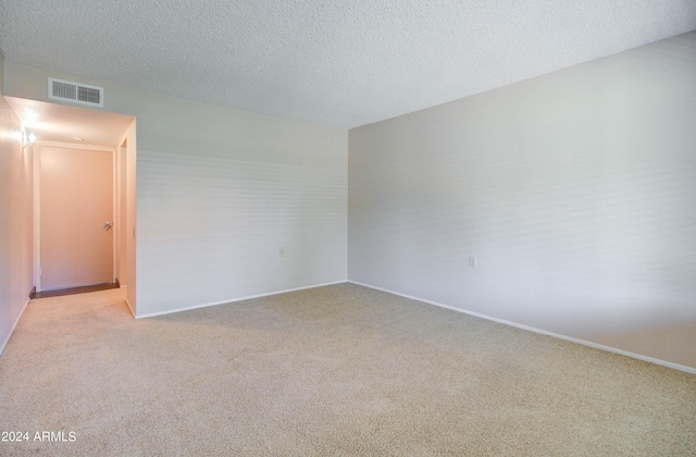 carpeted spare room with a textured ceiling