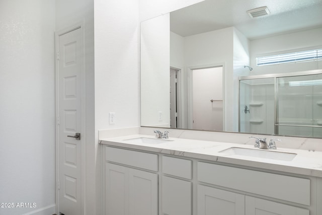 bathroom with vanity and a shower with door