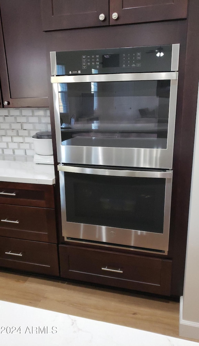 2060 E Quartz St, Mesa, AZ 85213 - kitchen featuring double oven, light wood-style floors, dark brown cabinetry, backsplash, and light countertops