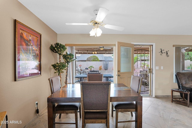 dining area featuring marble finish floor, baseboards, and ceiling fan