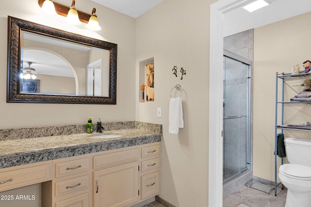 full bath featuring toilet, marble finish floor, a shower stall, baseboards, and vanity