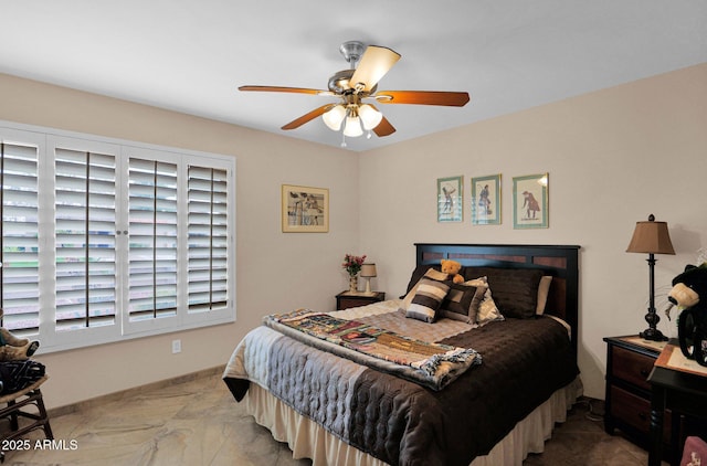 bedroom with a ceiling fan, baseboards, and marble finish floor