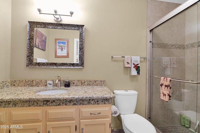 bathroom with vanity, a shower stall, and toilet