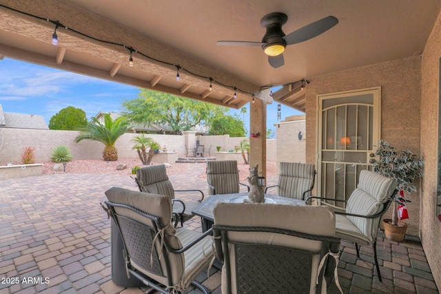 view of patio with outdoor dining space, a ceiling fan, and a fenced backyard