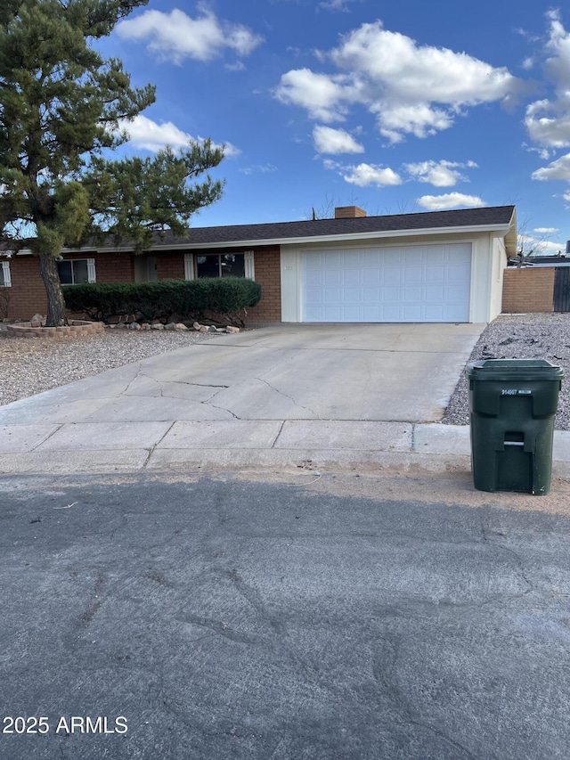 view of front facade featuring driveway, brick siding, and an attached garage