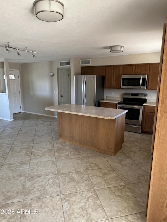 kitchen with visible vents, a kitchen island, appliances with stainless steel finishes, and light countertops