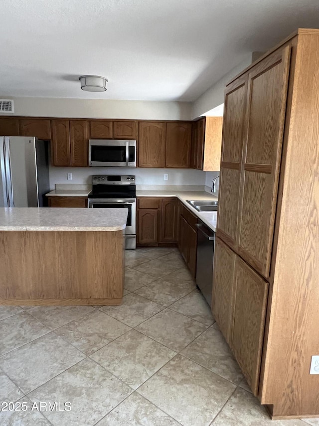 kitchen with visible vents, appliances with stainless steel finishes, light countertops, and a sink