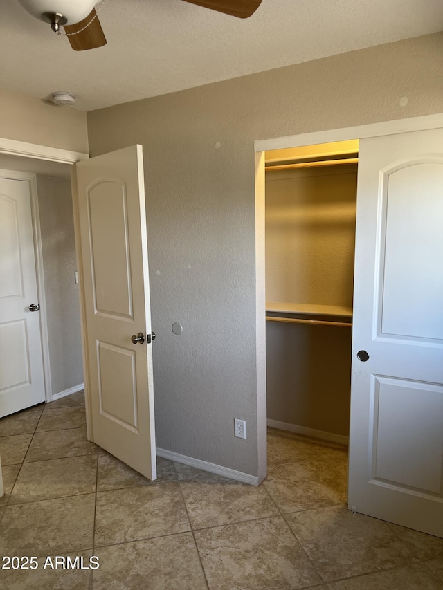 unfurnished bedroom featuring a ceiling fan, a closet, and baseboards