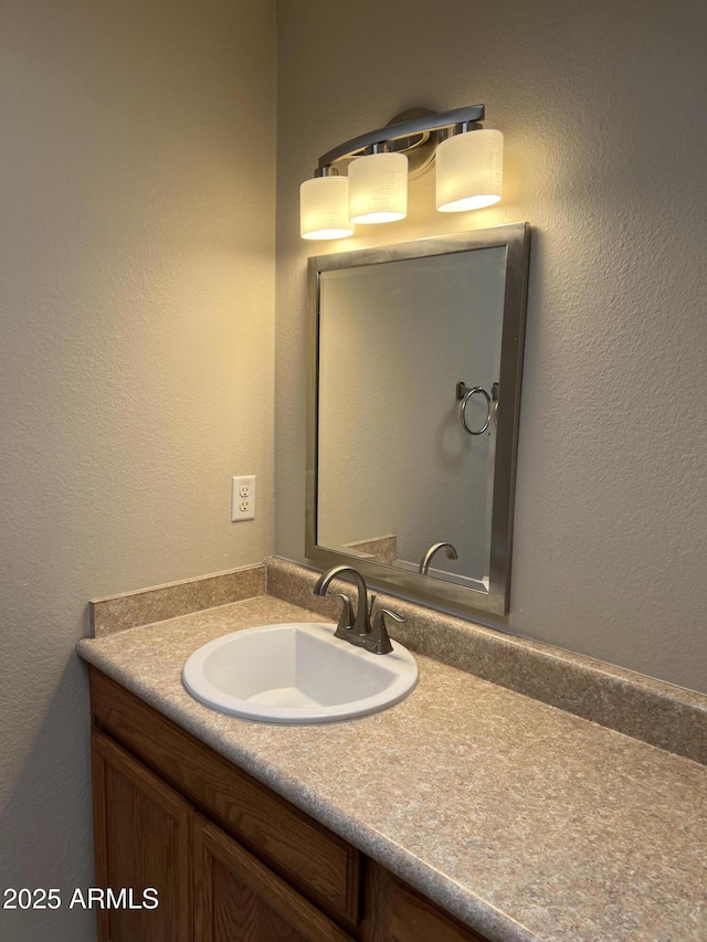 bathroom with a textured wall and vanity